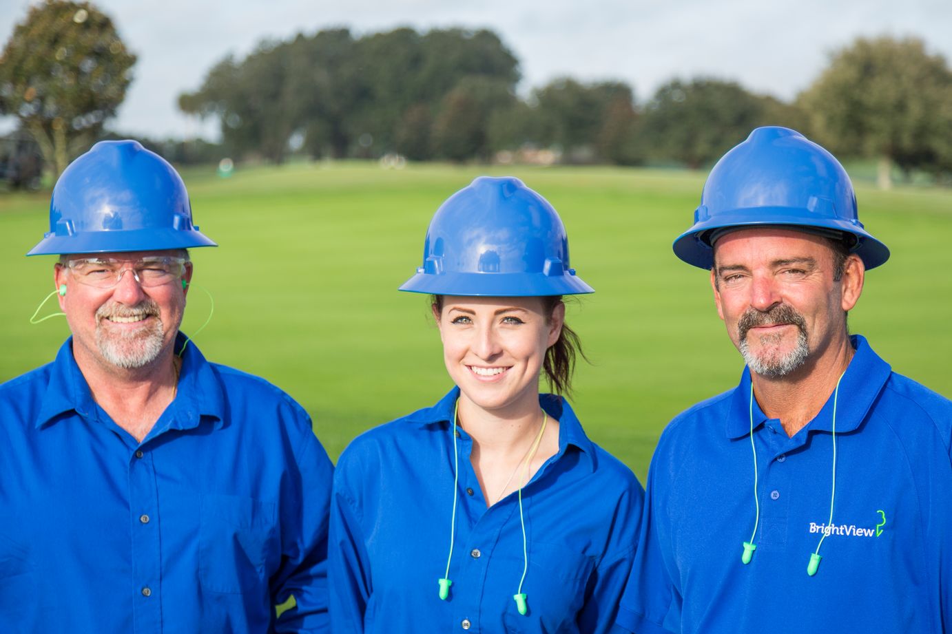 three golf course maintenance crew members