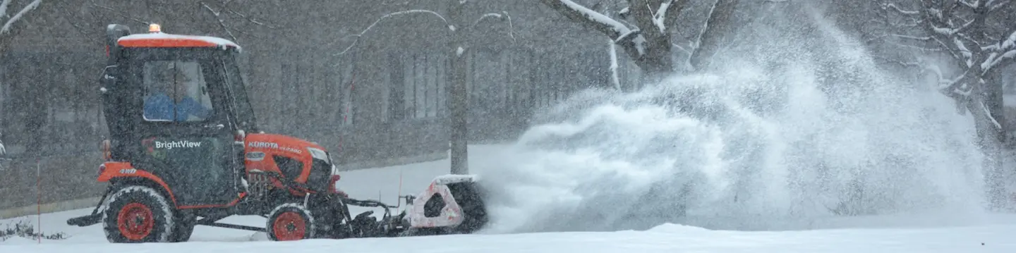snow plow with trees in background