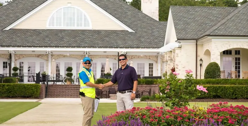 landscaper and property manager shaking hands on lawn
